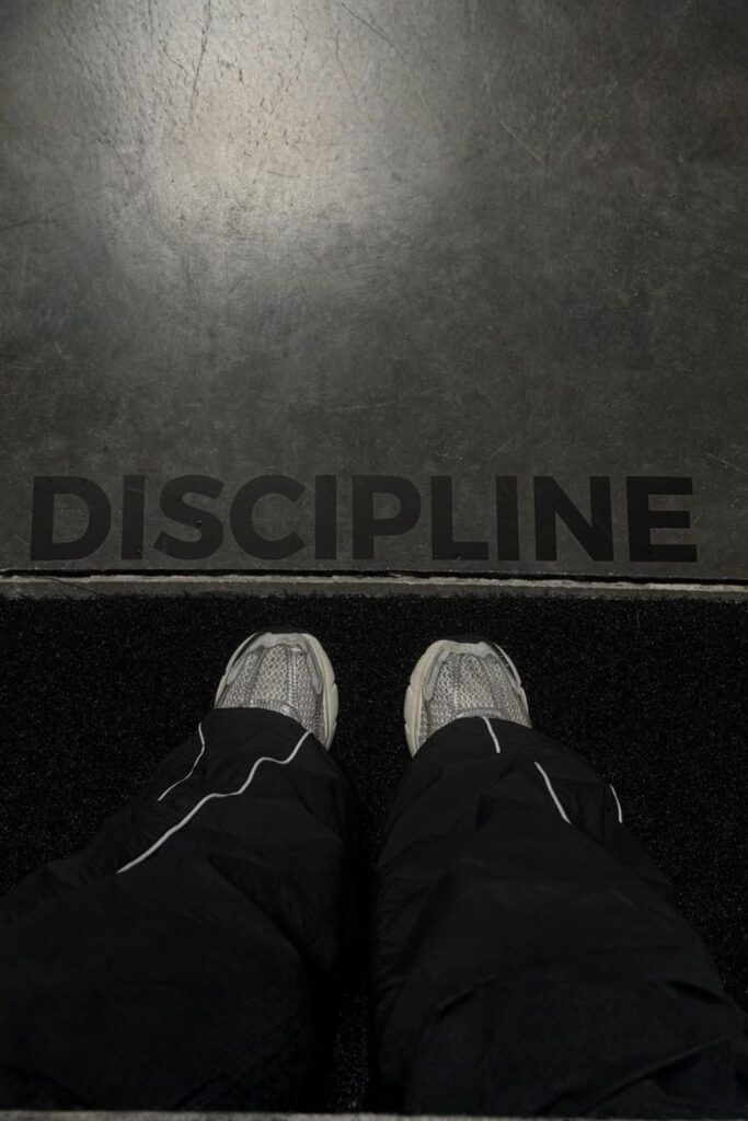 Chaussures de sport devant le mot "Discipline", symbole d'une routine sportive durable.